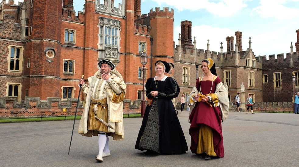Actors dressed up in traditional Tudor costumes as historical figures at Hampton Court Palace
